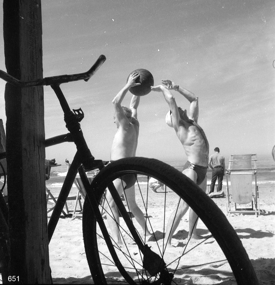 Bicicleta e homens na praia